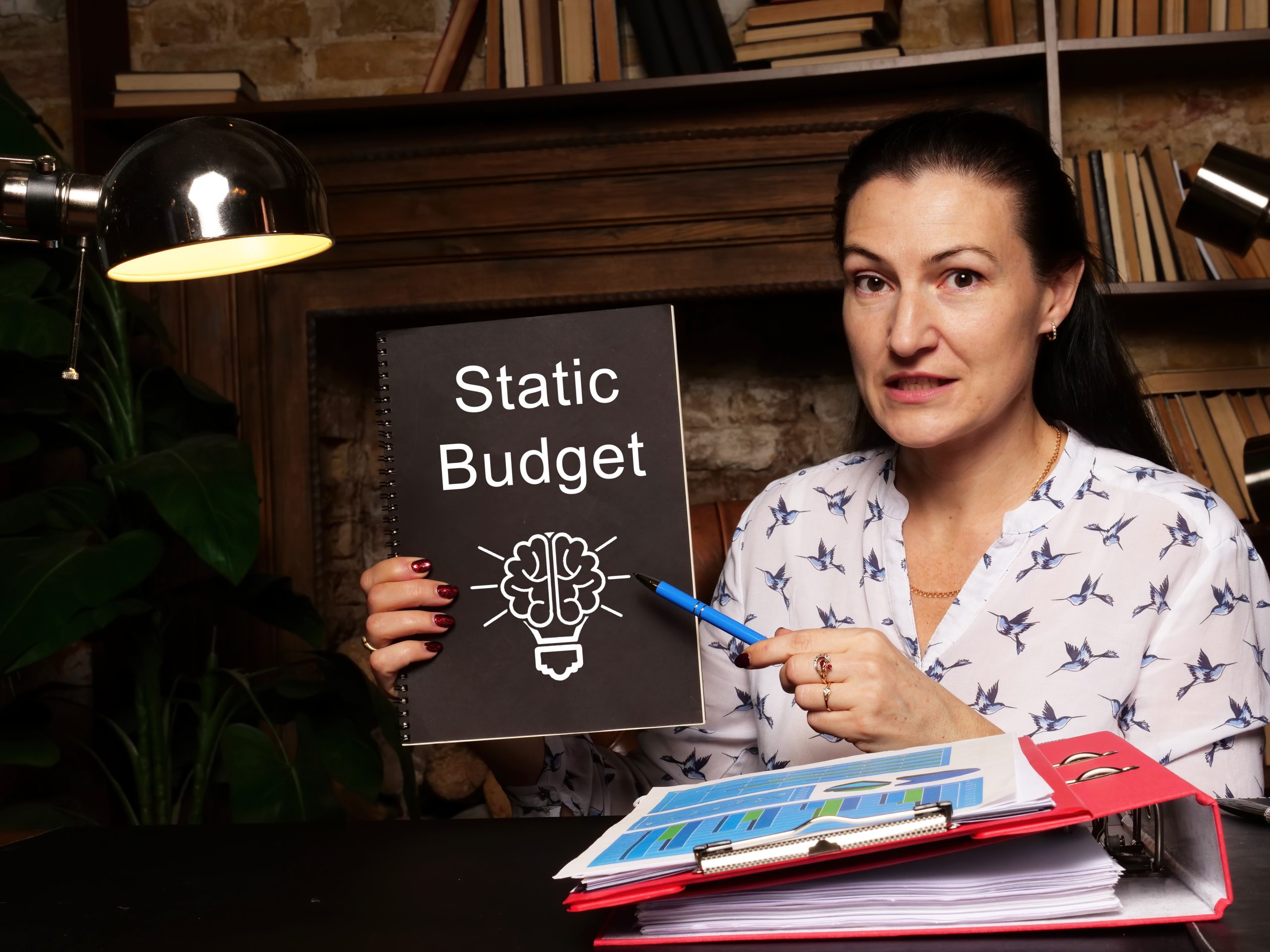 Woman pointing to a textbook with "Static Budget" printed on the front cover